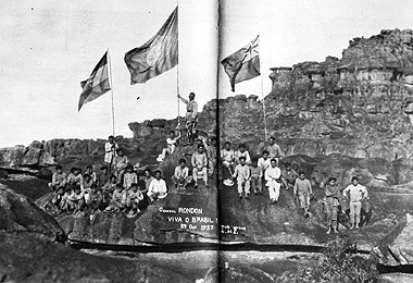  Trecho do filme <EM>Viagem ao Monte Roraima</EM> (1927), em cuja cena final Rondon aparece segurando a bandeira nacional ladeada pelas bandeiras da Venezuela e da Guiana, em meio a índios macuxis 