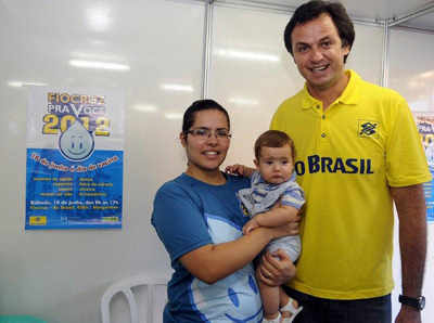  O ex-jogador olímpico de vôlei Carlão ao lado de voluntária da Fundação que levou o filho para vacinar 
