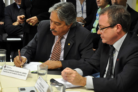  O presidente da Fiocruz, Paulo Gadelha, assina o acordo, observado pelo secretário do MS Carlos Gadelha 